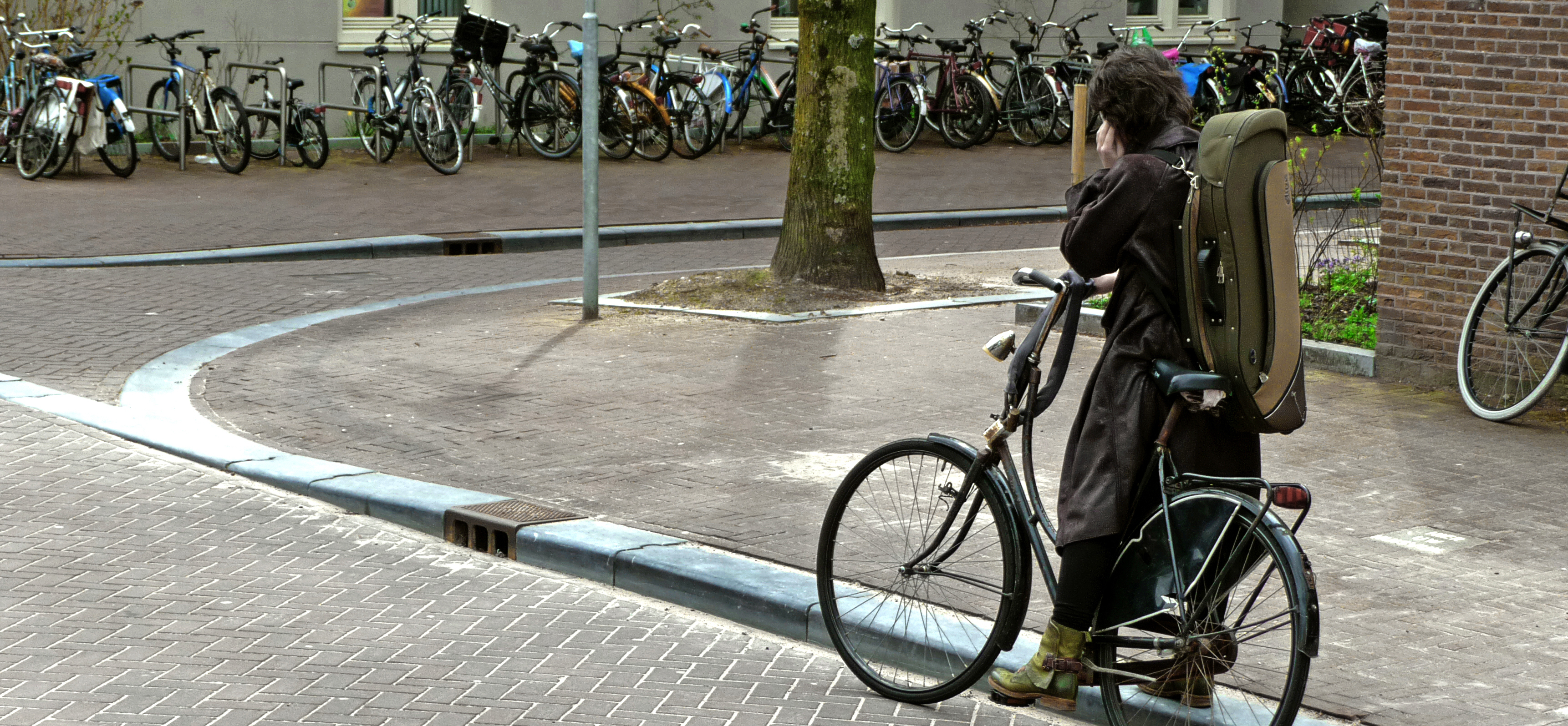 A girl on a bike with a violin on her back